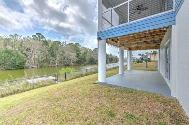 view of yard featuring fence, a patio area, and a water view