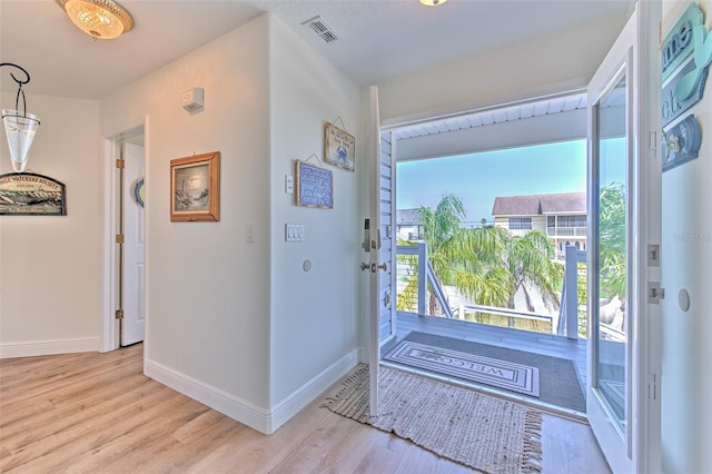 entrance foyer featuring visible vents, a healthy amount of sunlight, and wood finished floors