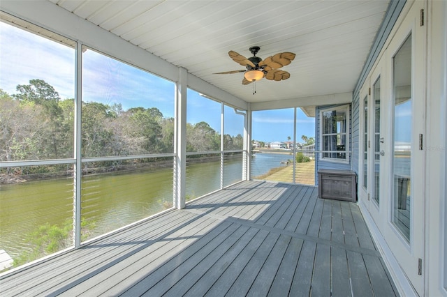 unfurnished sunroom with a water view and ceiling fan