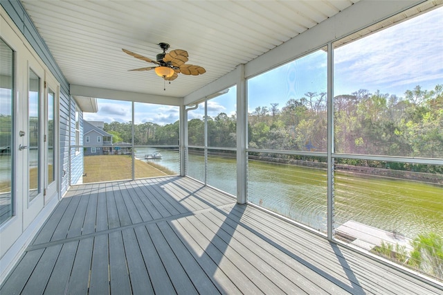 unfurnished sunroom with a water view and a ceiling fan