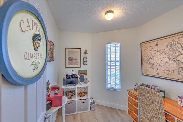 office featuring plenty of natural light, wood finished floors, baseboards, and a textured ceiling