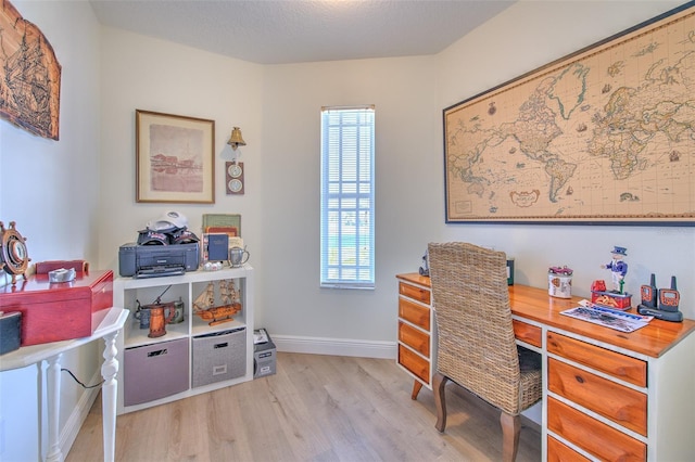 home office with baseboards, a textured ceiling, and light wood-style flooring