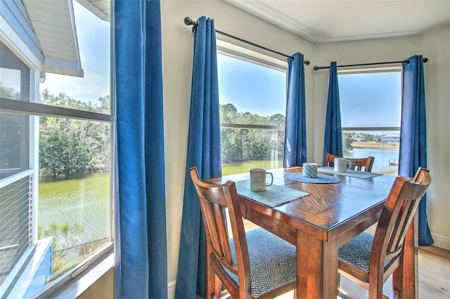 dining room featuring a water view and wood finished floors