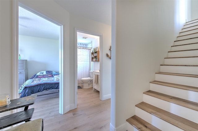 staircase with baseboards and wood finished floors