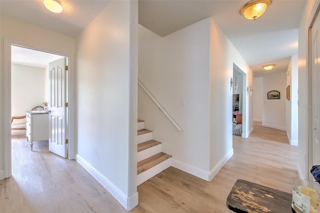 stairs with baseboards and wood finished floors