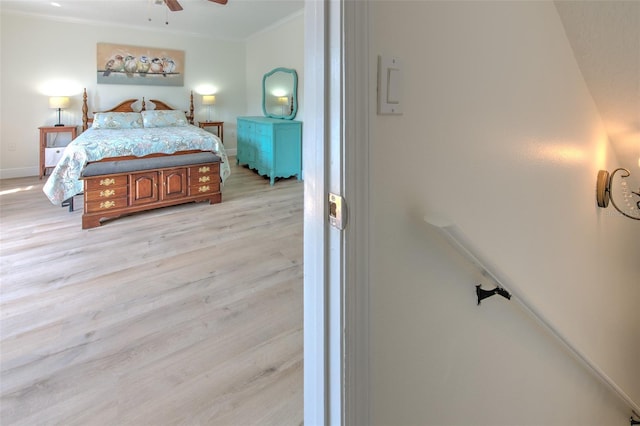 bedroom with baseboards, ornamental molding, and light wood finished floors