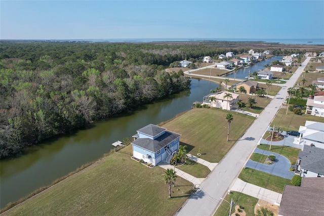 drone / aerial view featuring a forest view and a water view