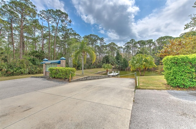 view of property's community with a lawn and driveway