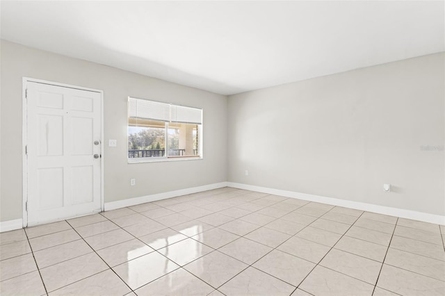 unfurnished room with light tile patterned floors and baseboards