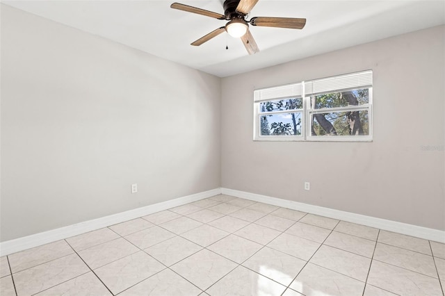 spare room featuring light tile patterned floors, a ceiling fan, and baseboards