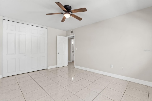 unfurnished bedroom with light tile patterned floors, visible vents, baseboards, and a closet