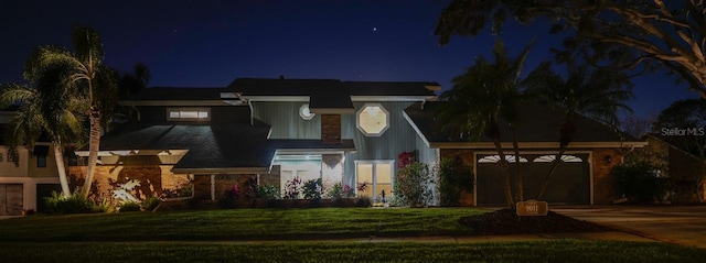 view of front of property with a lawn, driveway, and an attached garage