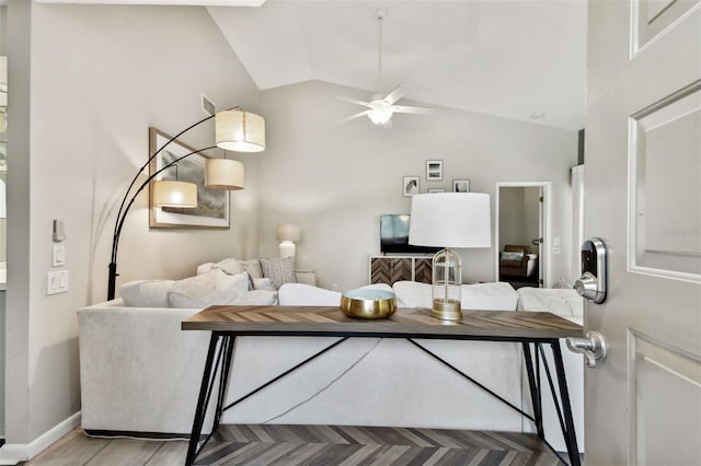 living room featuring lofted ceiling, a ceiling fan, and baseboards