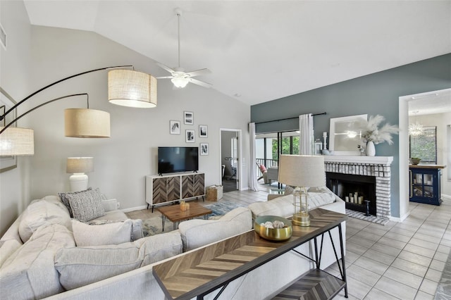 living area featuring ceiling fan, high vaulted ceiling, light tile patterned flooring, baseboards, and a brick fireplace