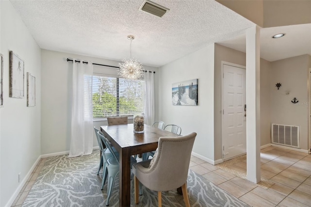 dining area featuring light tile patterned floors, visible vents, a chandelier, and a textured ceiling