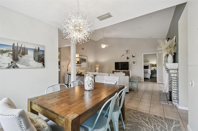 dining space with lofted ceiling, visible vents, tile patterned flooring, baseboards, and ceiling fan with notable chandelier