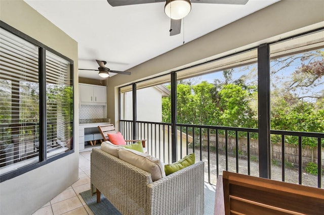 sunroom / solarium featuring plenty of natural light and a ceiling fan