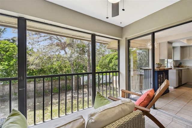 sunroom with a ceiling fan and a sink