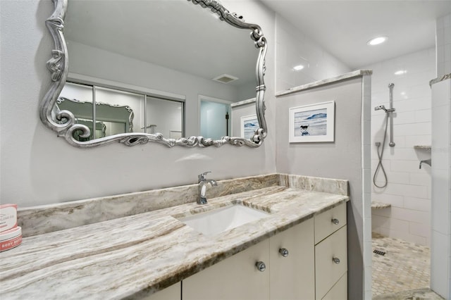 full bath with recessed lighting, visible vents, tiled shower, and vanity