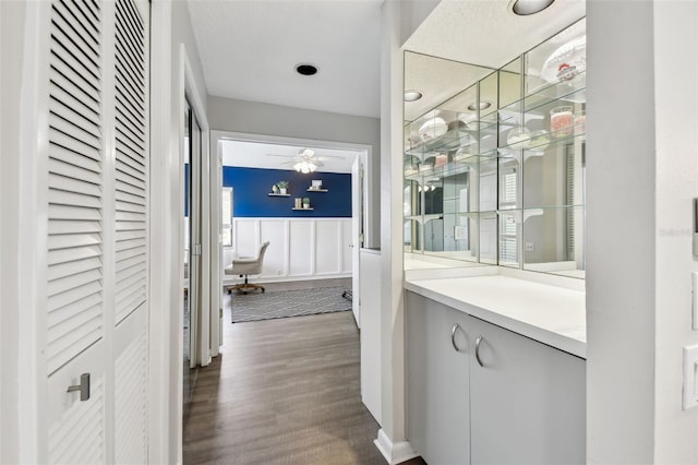 hall with dark wood-type flooring and wainscoting