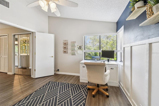 home office featuring a textured ceiling, visible vents, baseboards, vaulted ceiling, and dark wood finished floors