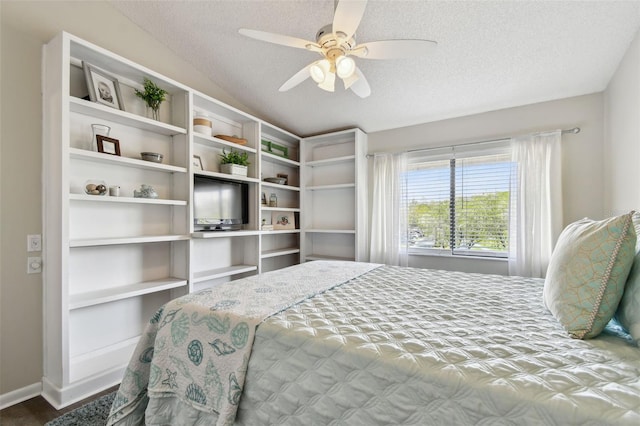 bedroom featuring vaulted ceiling, a textured ceiling, baseboards, and ceiling fan