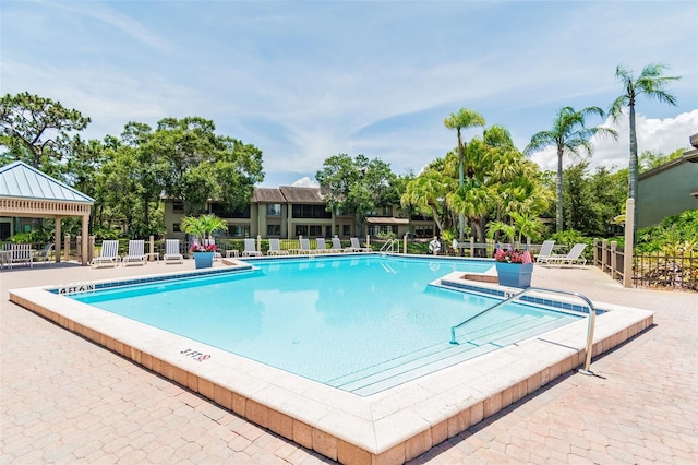 pool with a patio area and fence