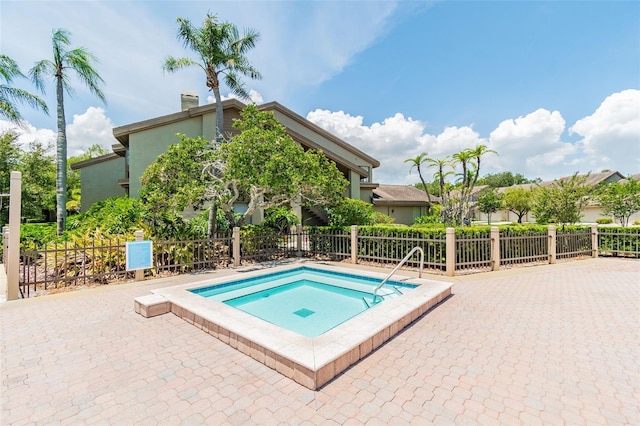 view of swimming pool with a patio area, fence, and a hot tub