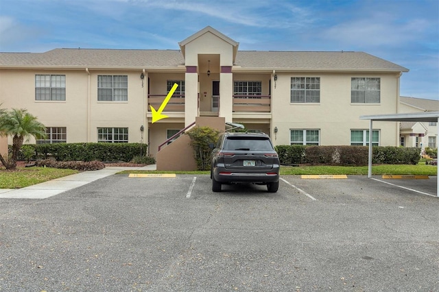 view of property featuring uncovered parking and stairway