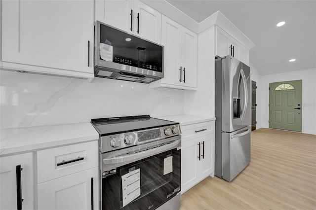 kitchen featuring light wood finished floors, recessed lighting, stainless steel appliances, white cabinetry, and tasteful backsplash