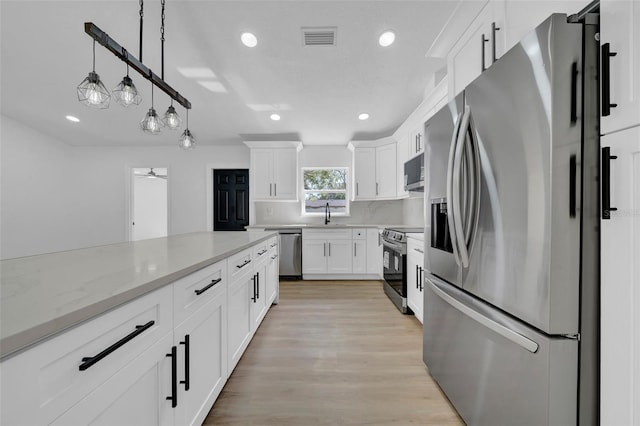 kitchen featuring visible vents, recessed lighting, stainless steel appliances, white cabinets, and light wood-style floors