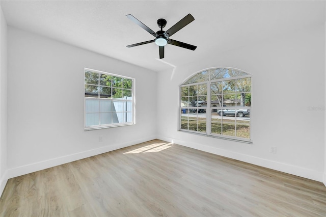 unfurnished room with ceiling fan, baseboards, and wood finished floors