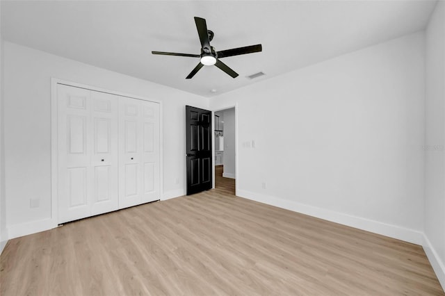 unfurnished bedroom featuring baseboards, visible vents, a closet, and light wood-type flooring