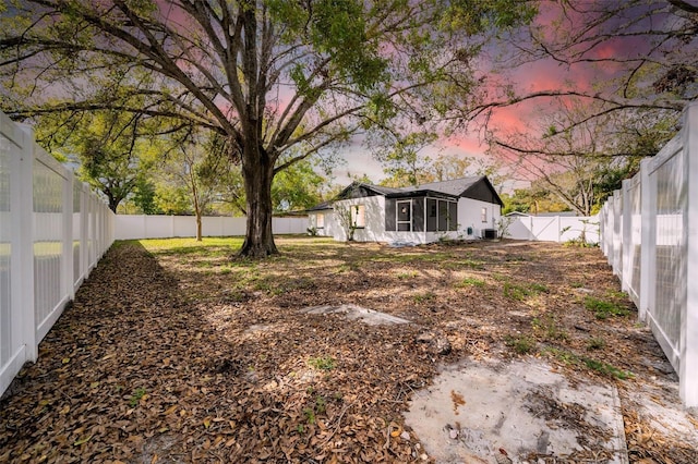 yard at dusk with a fenced backyard