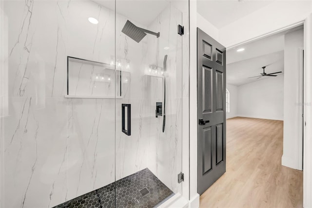 bathroom with a marble finish shower, a ceiling fan, and wood finished floors