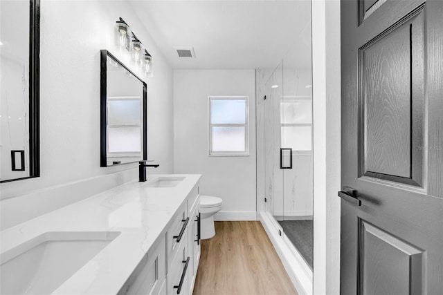 full bathroom with a sink, visible vents, toilet, and wood finished floors