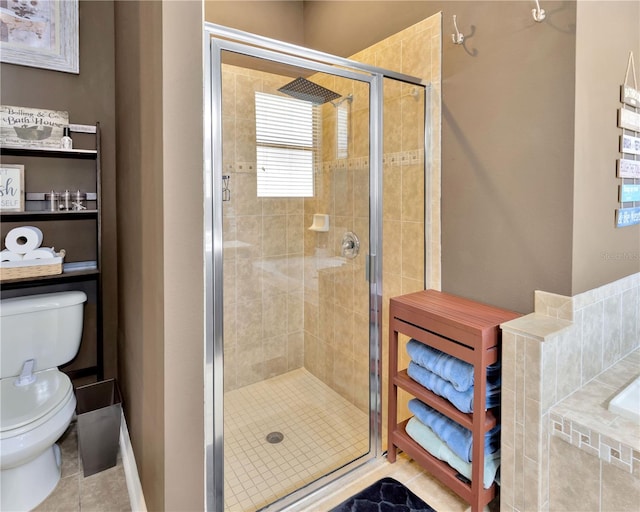 bathroom featuring tile patterned floors, toilet, and a shower stall