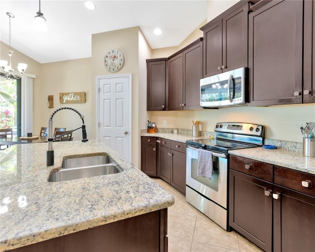kitchen with dark brown cabinetry, decorative light fixtures, light tile patterned floors, stainless steel appliances, and a sink