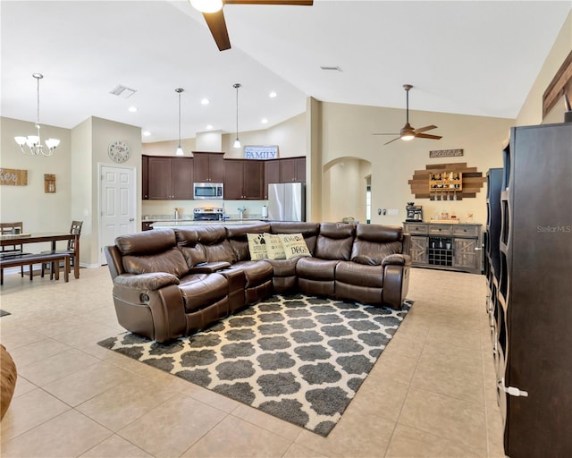 living area featuring visible vents, arched walkways, light tile patterned flooring, and ceiling fan with notable chandelier