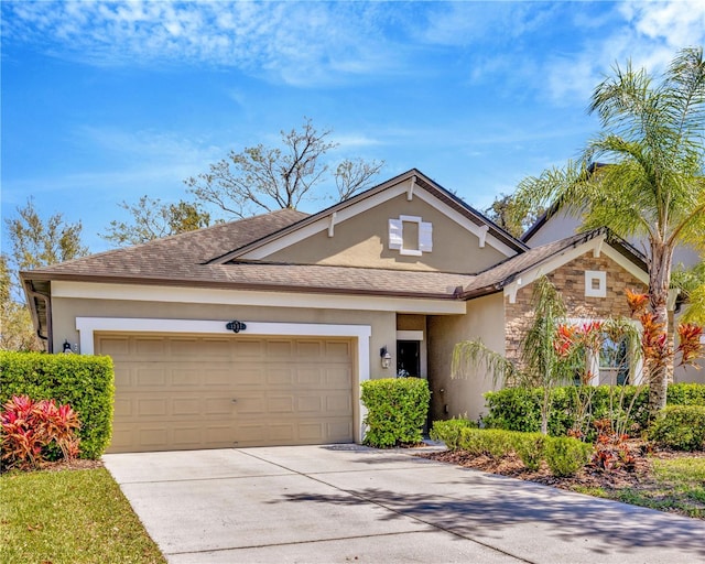 view of front of property featuring a shingled roof, concrete driveway, stucco siding, a garage, and stone siding