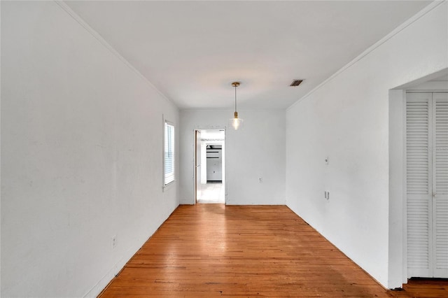 unfurnished dining area featuring visible vents, crown molding, and hardwood / wood-style flooring