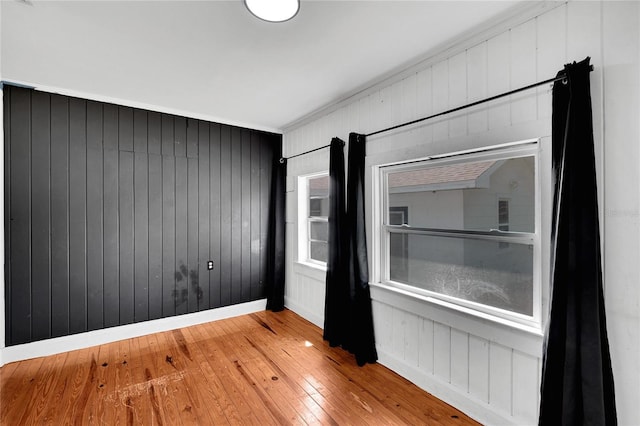 empty room with baseboards and hardwood / wood-style floors