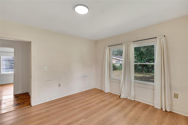 empty room with light wood-style floors and baseboards