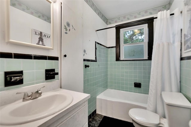 bathroom with shower / tub combo, vanity, toilet, and tile walls