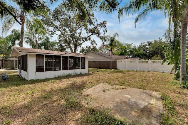 view of yard featuring a fenced backyard and a sunroom