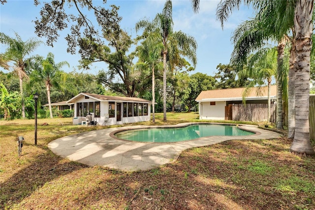 outdoor pool featuring a yard and a sunroom