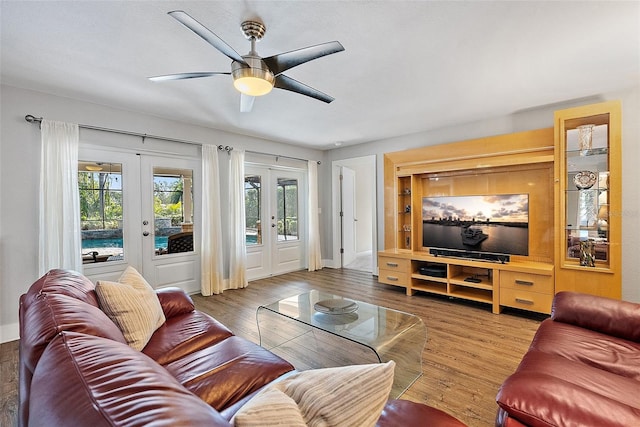 living room with french doors, ceiling fan, baseboards, and wood finished floors