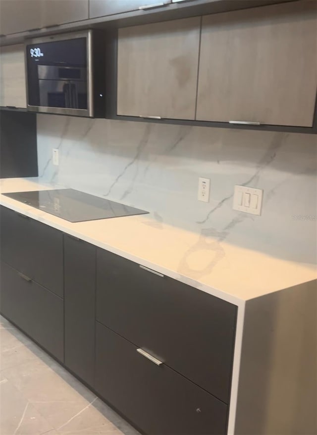 kitchen with modern cabinets, decorative backsplash, and light countertops