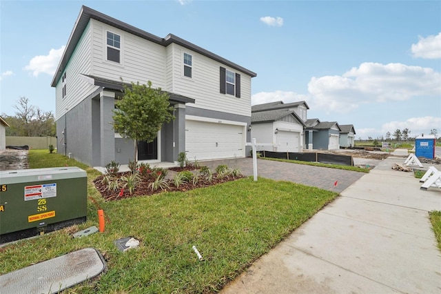 view of front of home with a front lawn, decorative driveway, a garage, and stucco siding