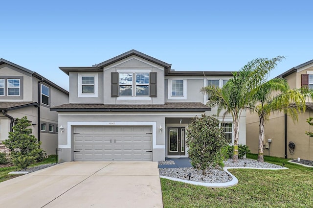 view of front of home featuring driveway, a garage, and stucco siding